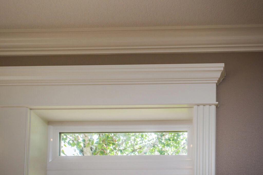 Close-up of layered crown molding and fluted window trim demonstrating detailed craftsmanship by Black Cat Design Build LLC.