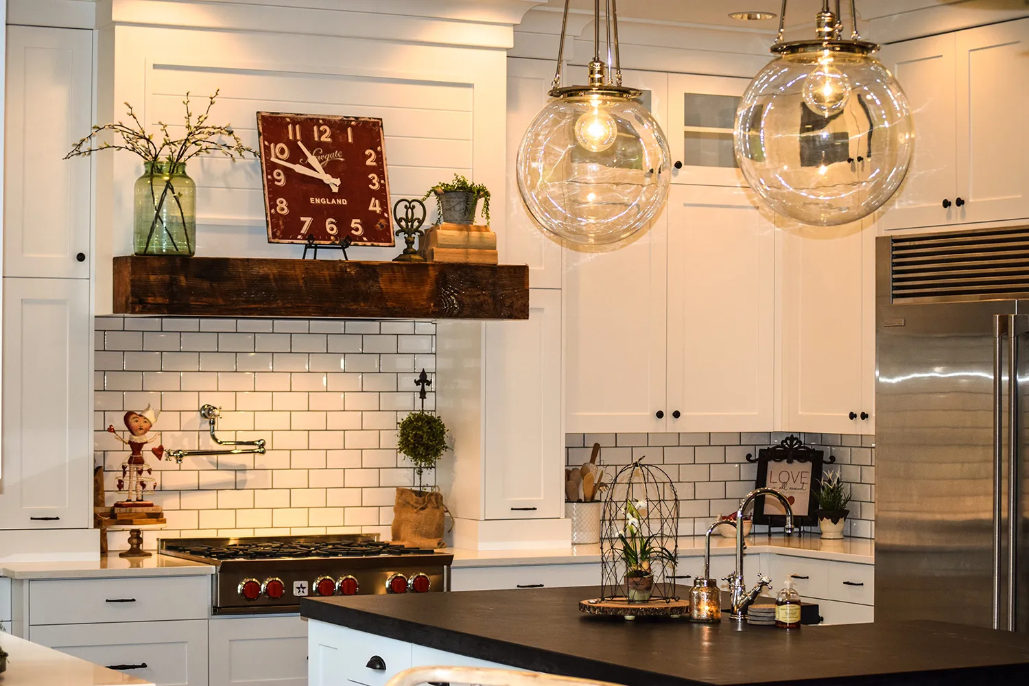 Farmhouse kitchen with white shaker cabinets, a subway tile backsplash, glass globe pendants, and a professional gas range.