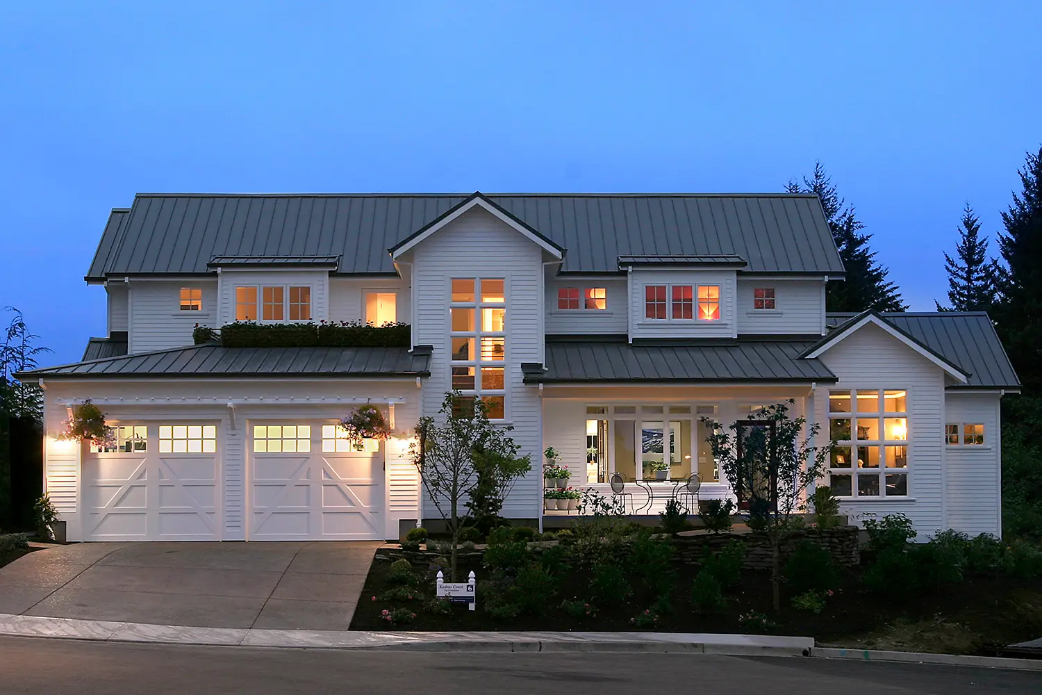 Custom two-story white home with a dark metal roof, covered porch, and carriage-style garage doors built by Black Cat Design Build LLC in Clark County, WA.