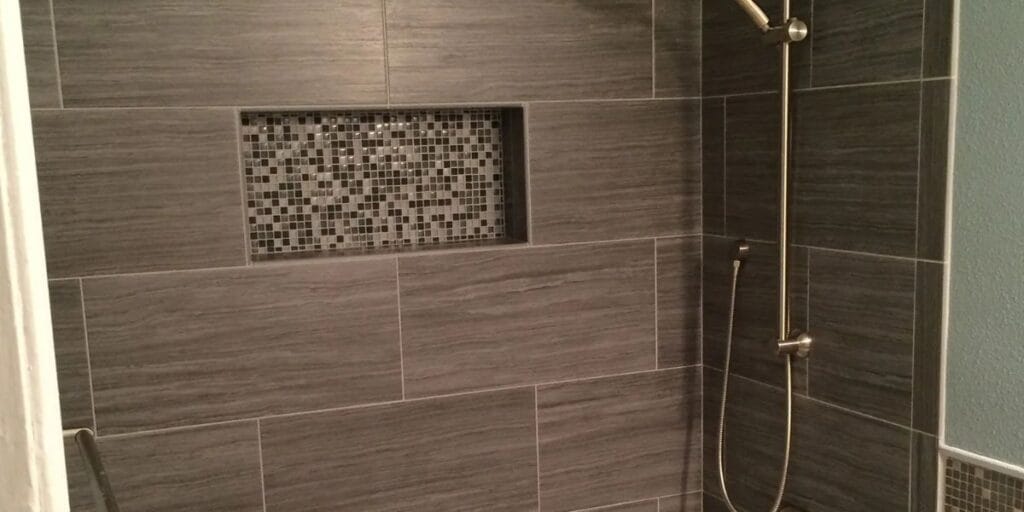 Contractor and homeowners reviewing structural layout plans for a bathroom remodel before construction begins | How To Plan a Structural Layout for a Bathroom Remodel
