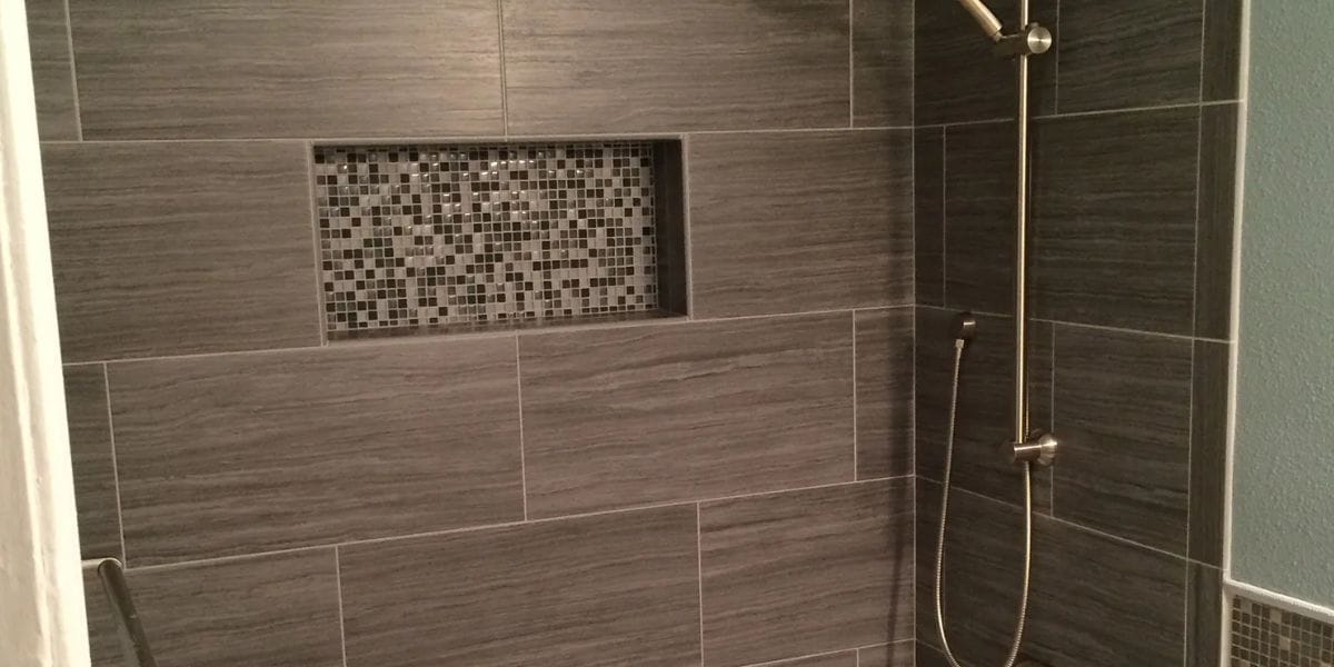 Contractor and homeowners reviewing structural layout plans for a bathroom remodel before construction begins | How To Plan a Structural Layout for a Bathroom Remodel